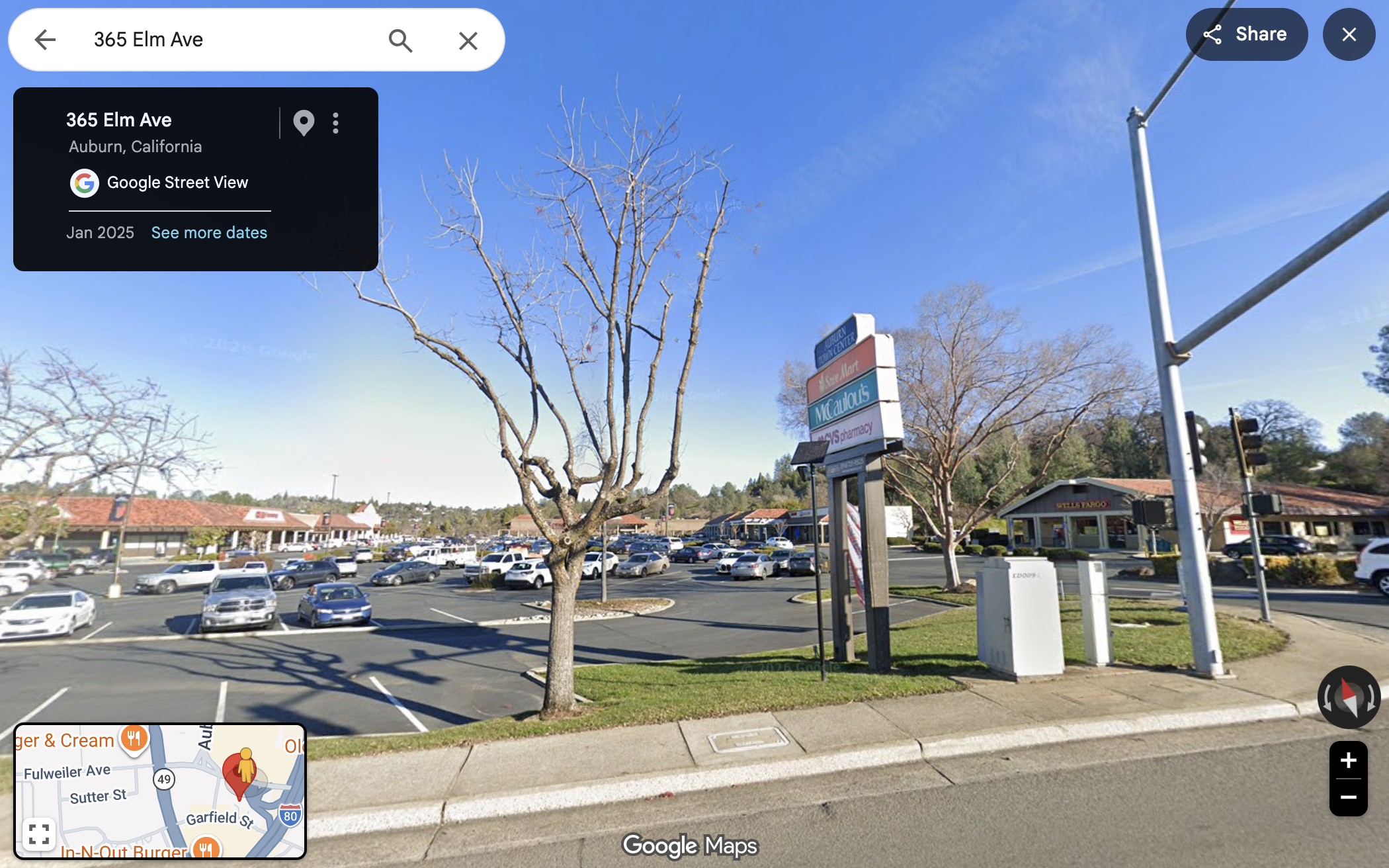 ALPR camera on a pole blocking shopping center signs, against a blue sky