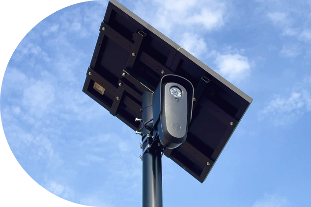 An ALPR camera mounted on a pole with a solar panel, against a blue sky